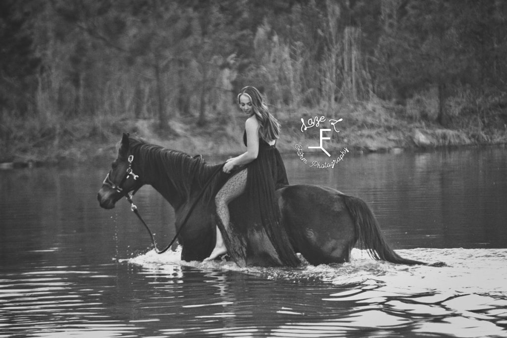 girl riding horse in the water