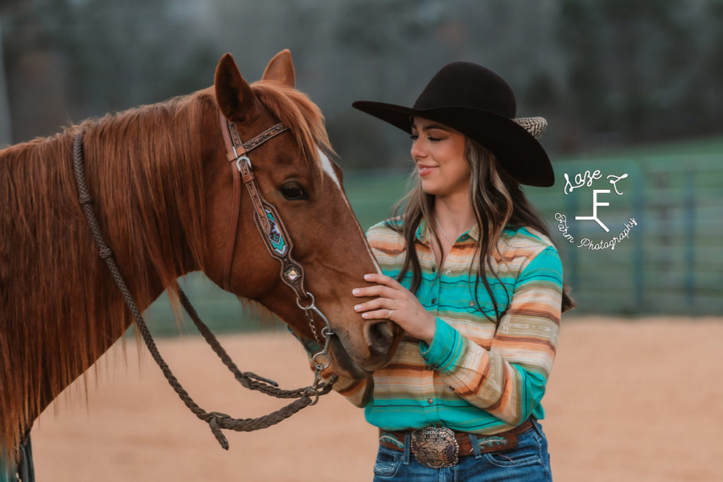 cowgirl in western shirt loving on horse