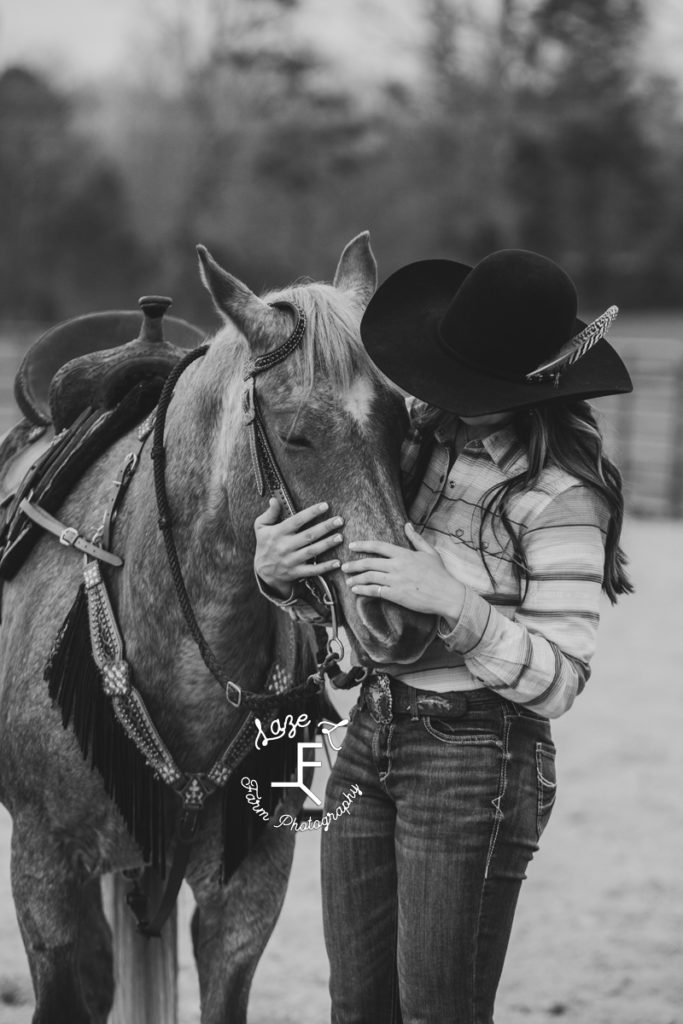 cowgirl loving on horse in black and white