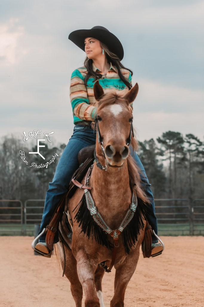 cowgirl riding red roan