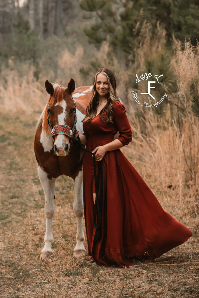 girl in long burnt orange dress with paint horse