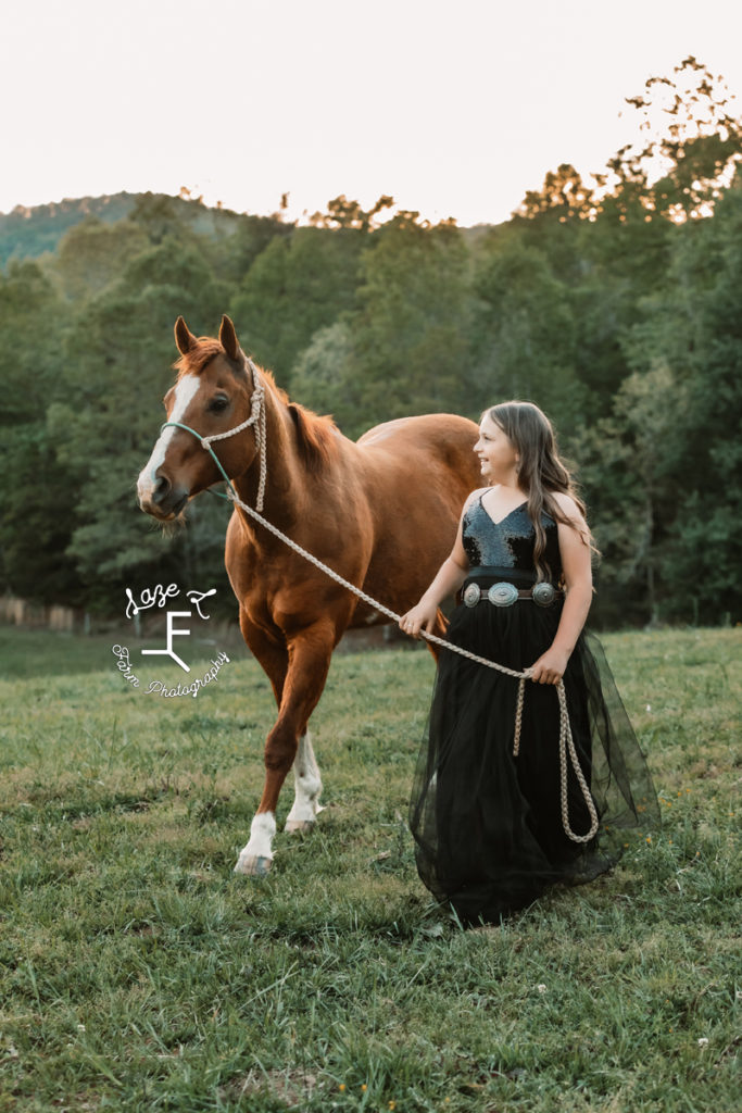 little girl in black dress with her horse