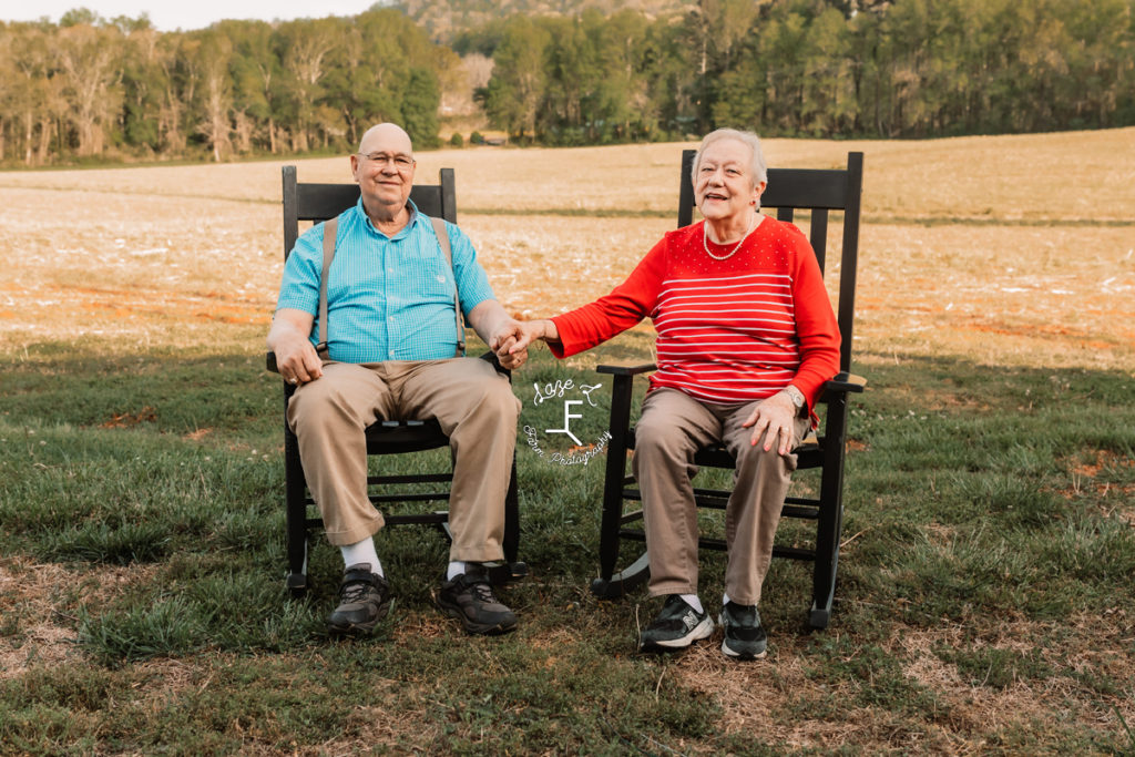 grandparents holding hands in rocking chairs