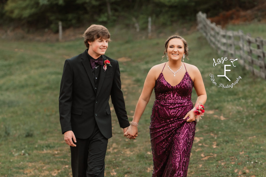 prom couple in purple and black walking