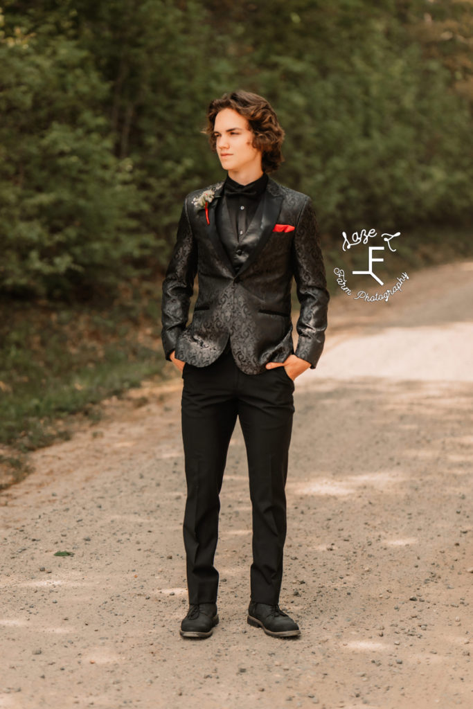 high school boy in black metallic suit jacket with red pocket square