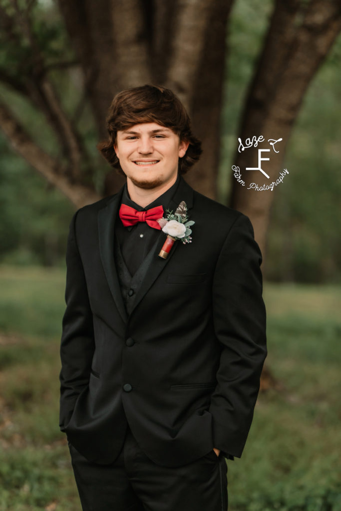 high school boy in black tux with red bowtie