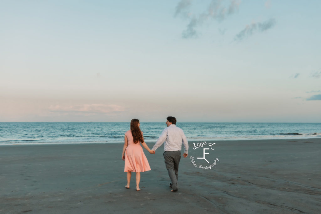 couple walking towards the ocean