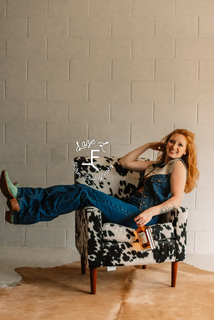 red head in cow print chair with patron