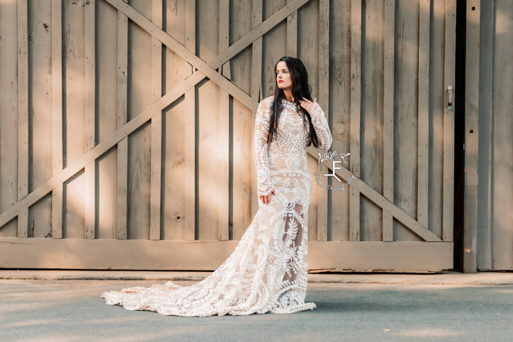 woman in lace wedding dress in front of wooden wall