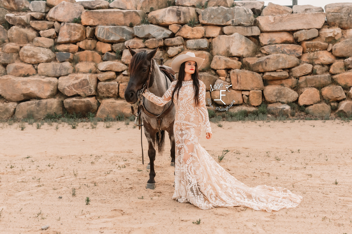 cowgirl standing with roan horse in lace dress