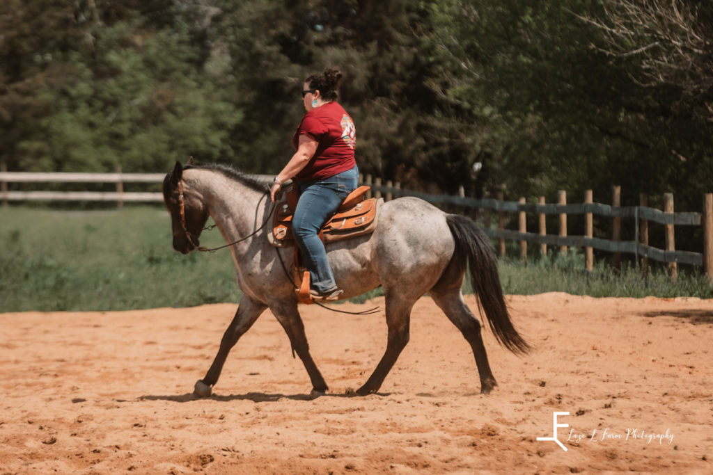 rider on blue roan trotting