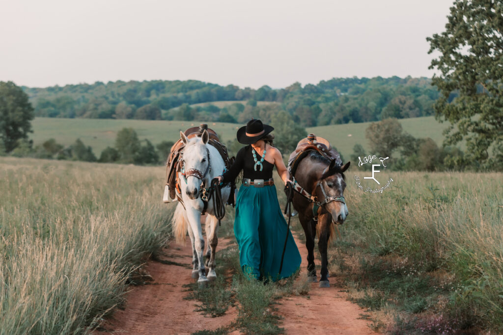 cowgirl in teal skirt with gray and roan horses