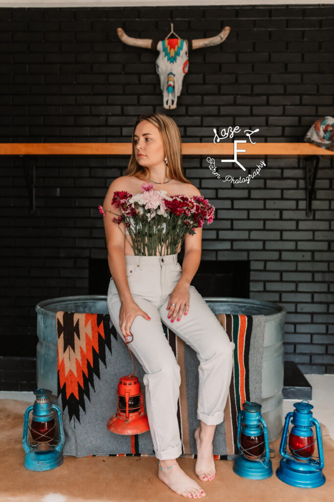 girl with flower pants sitting on water trough