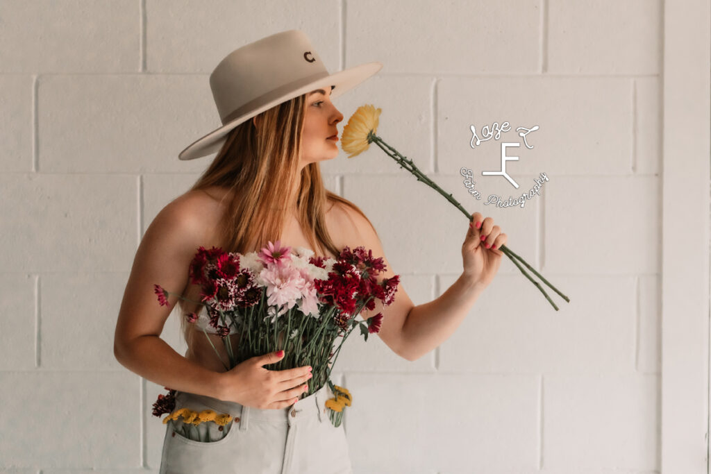 cowgirl smelling yellow flowers in flower pants