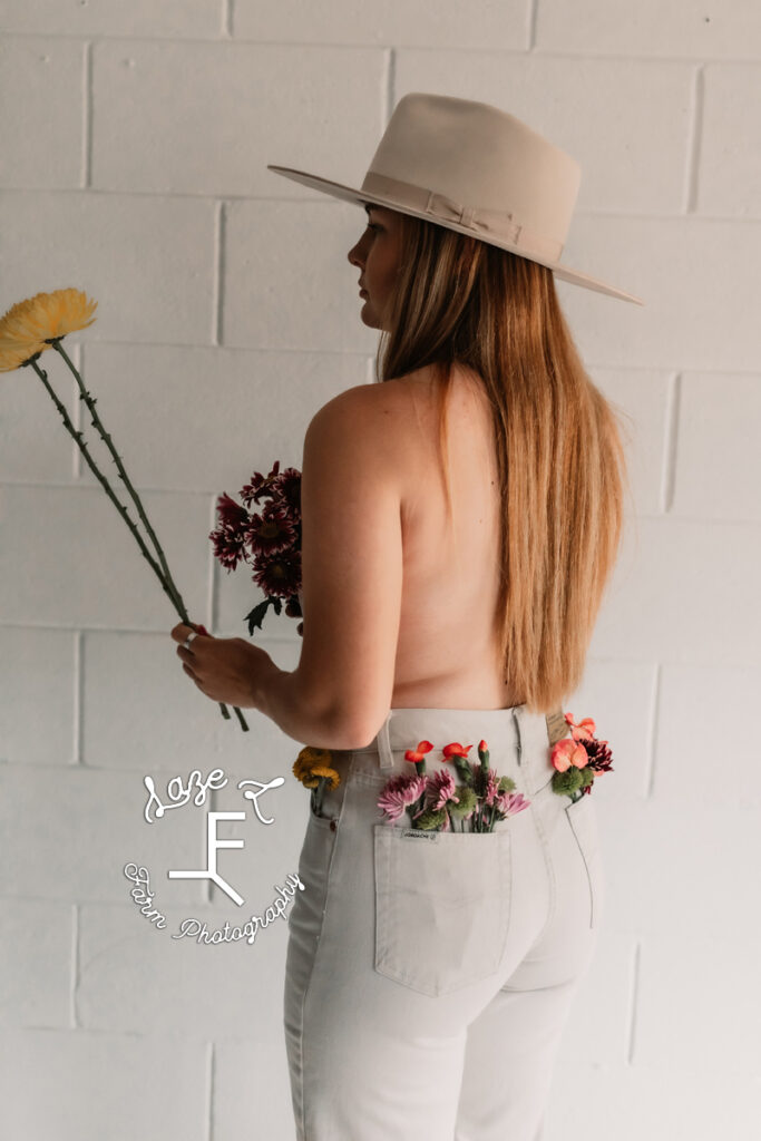 cowgirl holding flowers with flowers in her back pockets