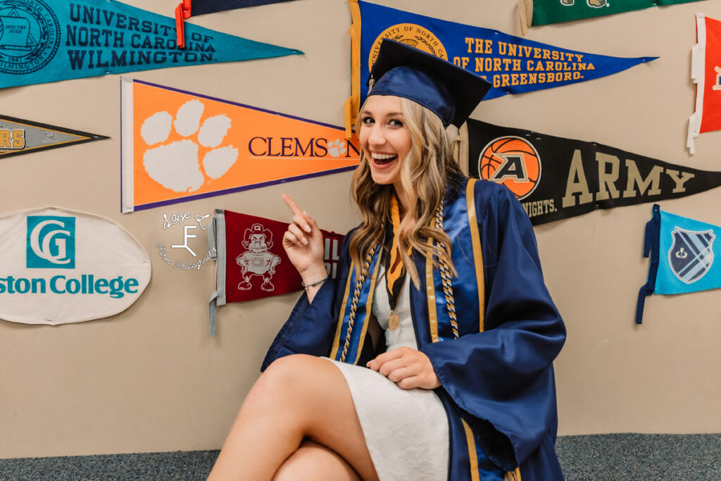 senior girl sitting in cap and gown with Clemson sports flag