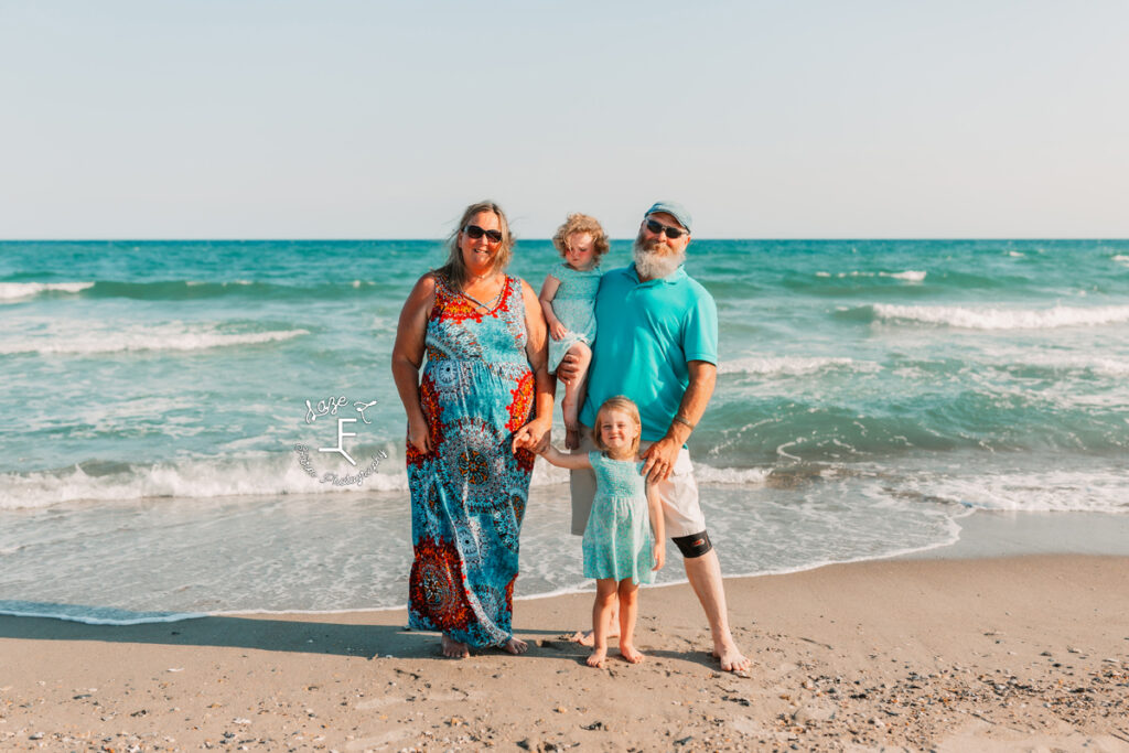 grandparents with granddaughters in front of the ocean
