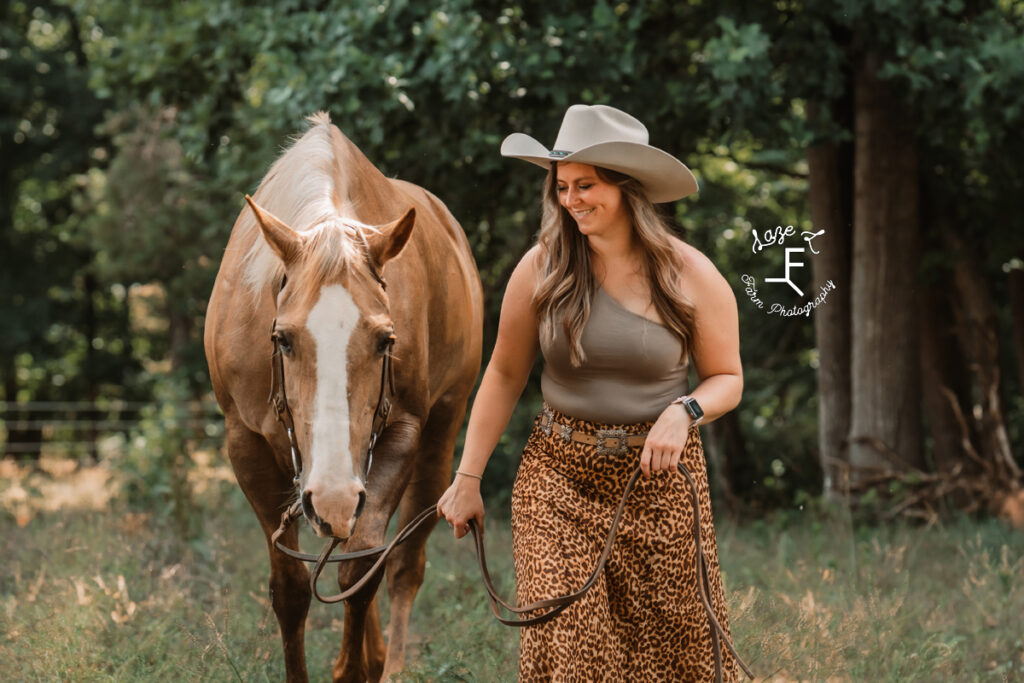 cowgirl walking with her mare