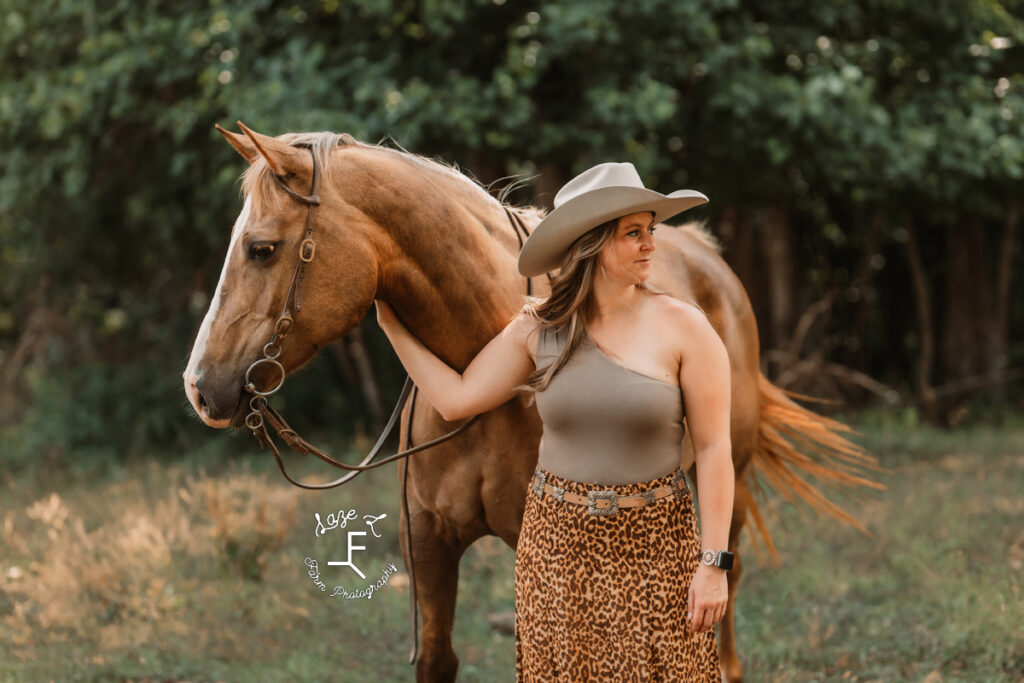 cowgirl looking right with her horse looking left