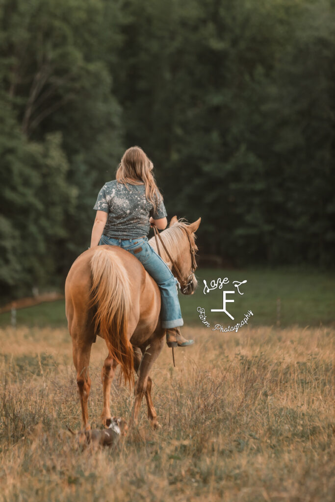 girl riding mare away from camera