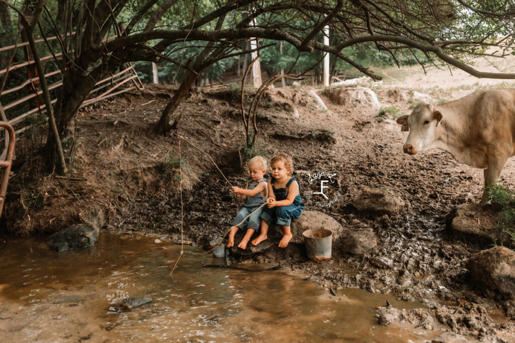 brothers sitting at the creek with homemade fishing poles