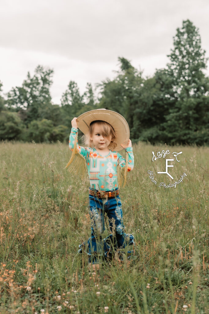 little cowgirl grabbing her hat