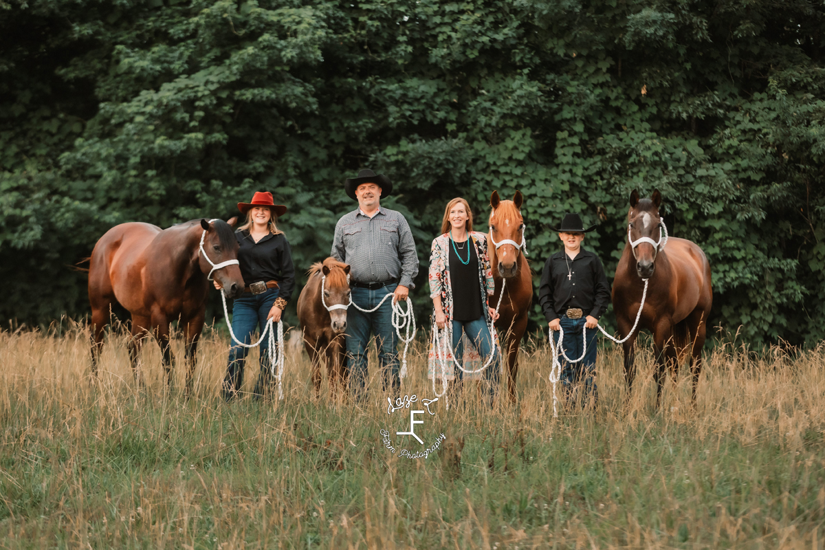 family of 4 with 3 horses and a pony