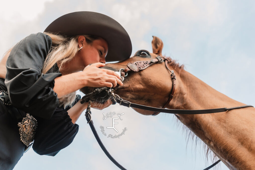 cowgirl kissing dunn horse shot from under the