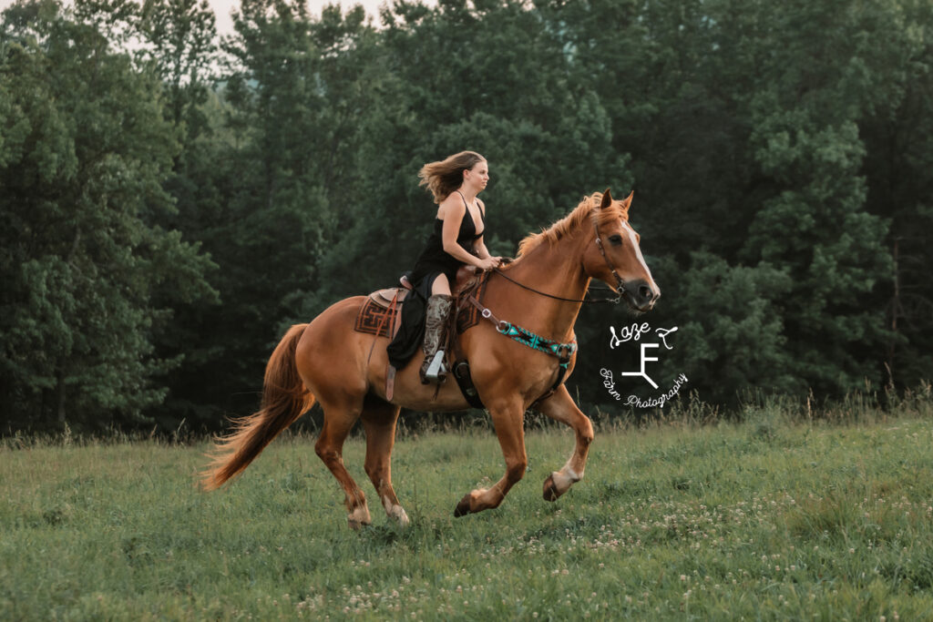 girl in black dress loping through field on horseback