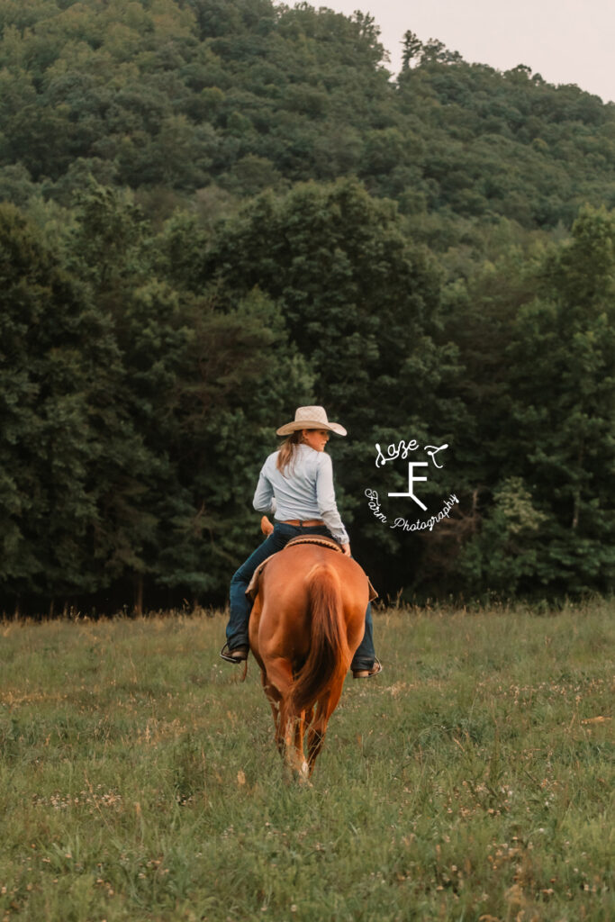 sister riding sorrel horse away from camera