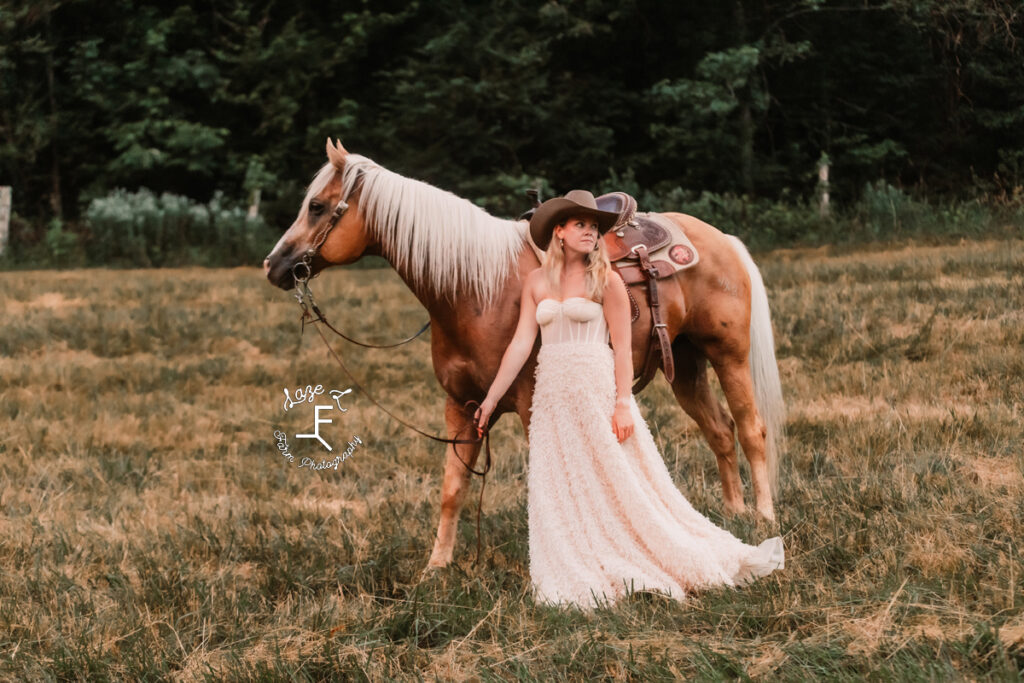cowgirl in white dress with palomino looking opposite directions