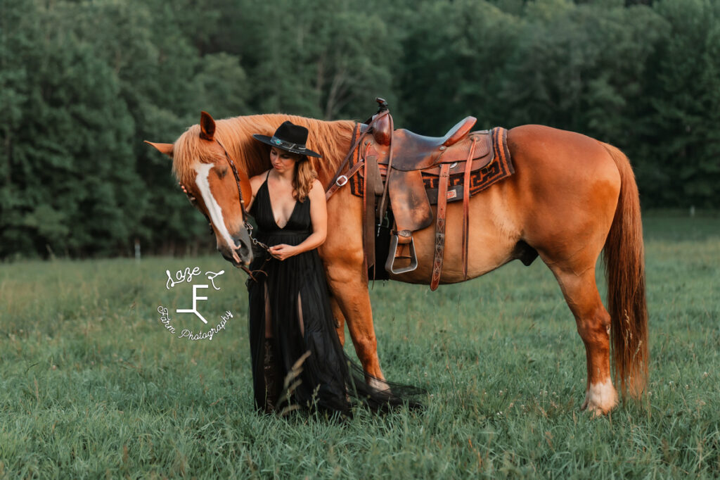 cowgirl in black dress standing with horse