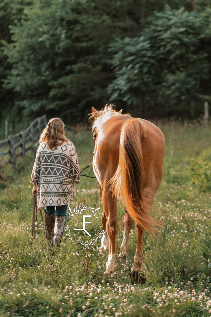 girl in western print kimono walking with horse away from the camera