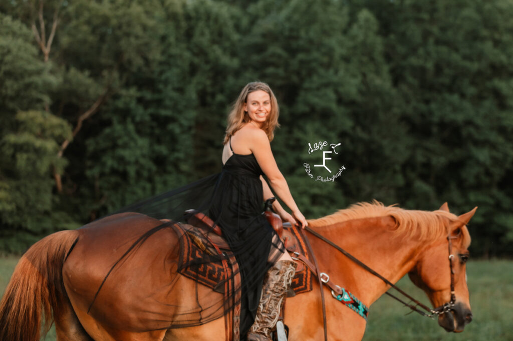 cowgirl in black dress on horseback
