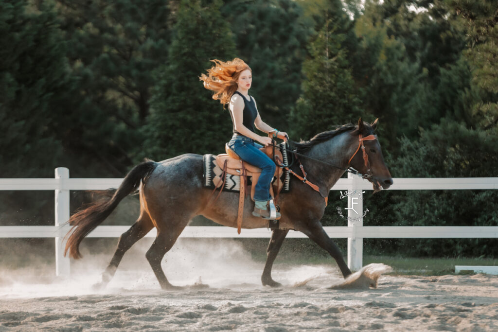 redhaired cowgirl on roan horse loping