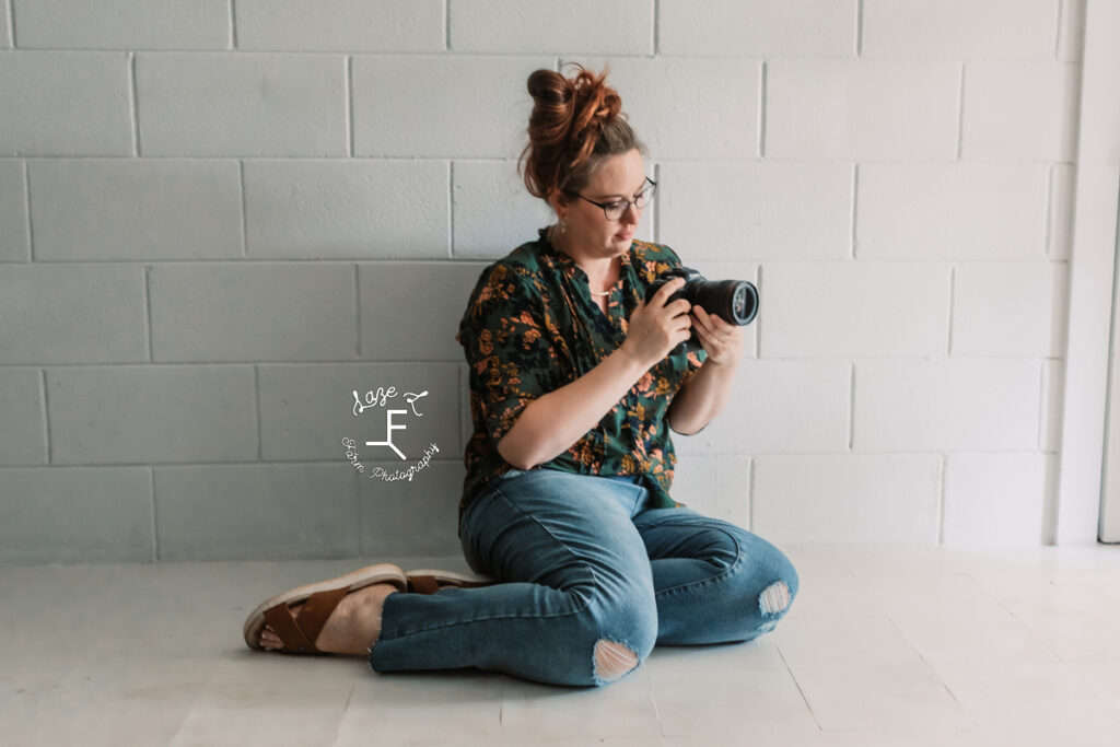 photographer sitting in floor looking at camera