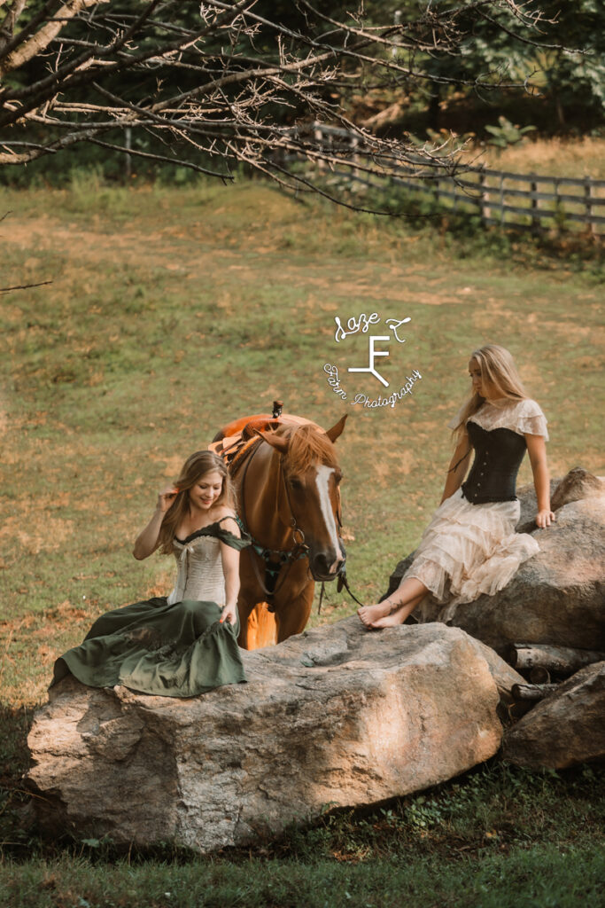 2 models in vintage dresses with a horse