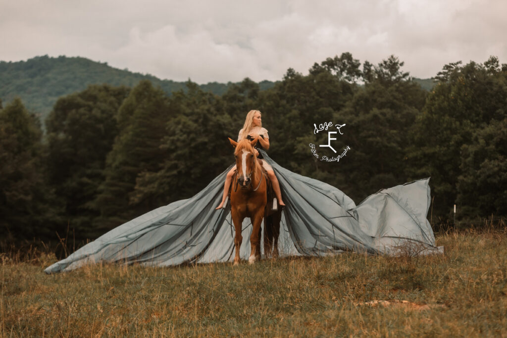 blonde model in parachute dress on brown horse