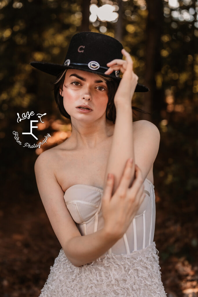 model in white dress with black hat