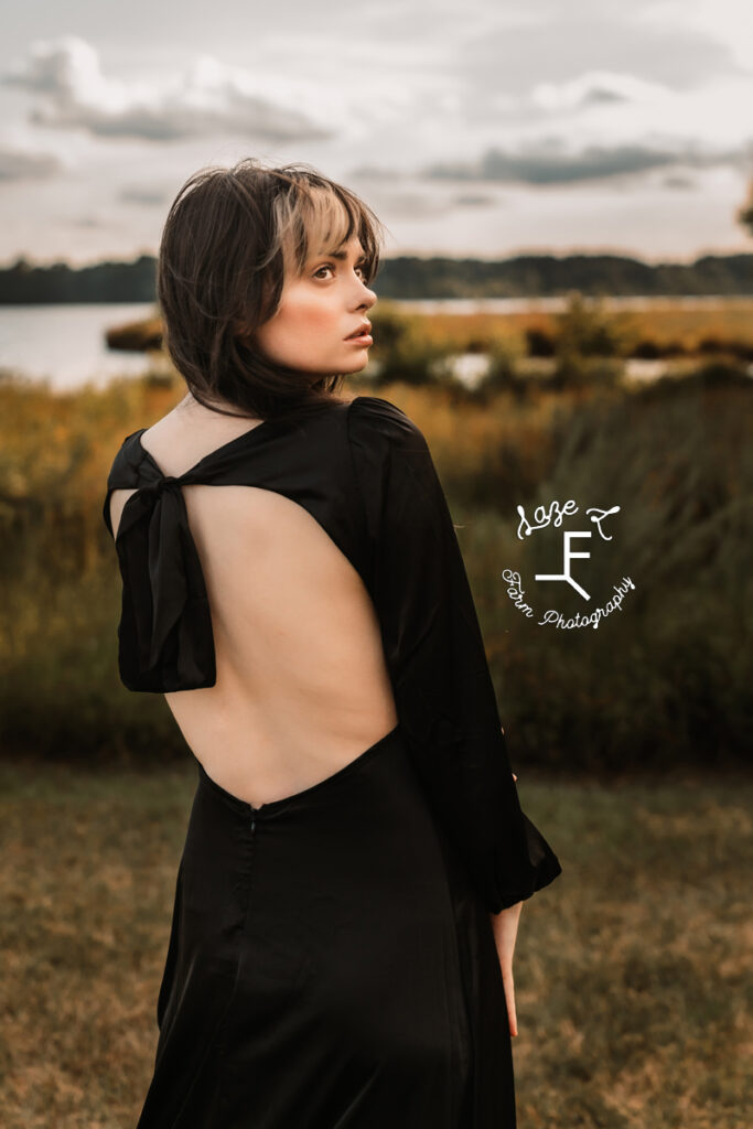Model in black dress looking over shoulder