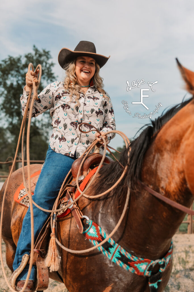 cowgirl holding rope on horseback