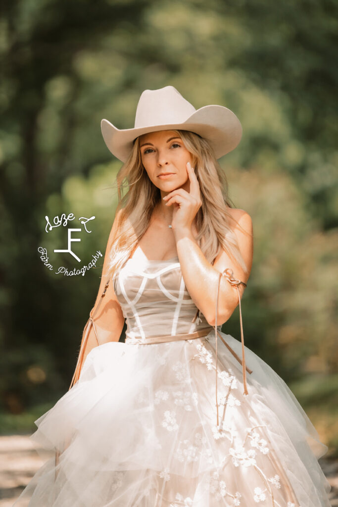 model in tan cowboy hat in tan and white dress