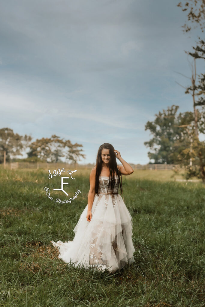 model wearing tan and white dress in a field