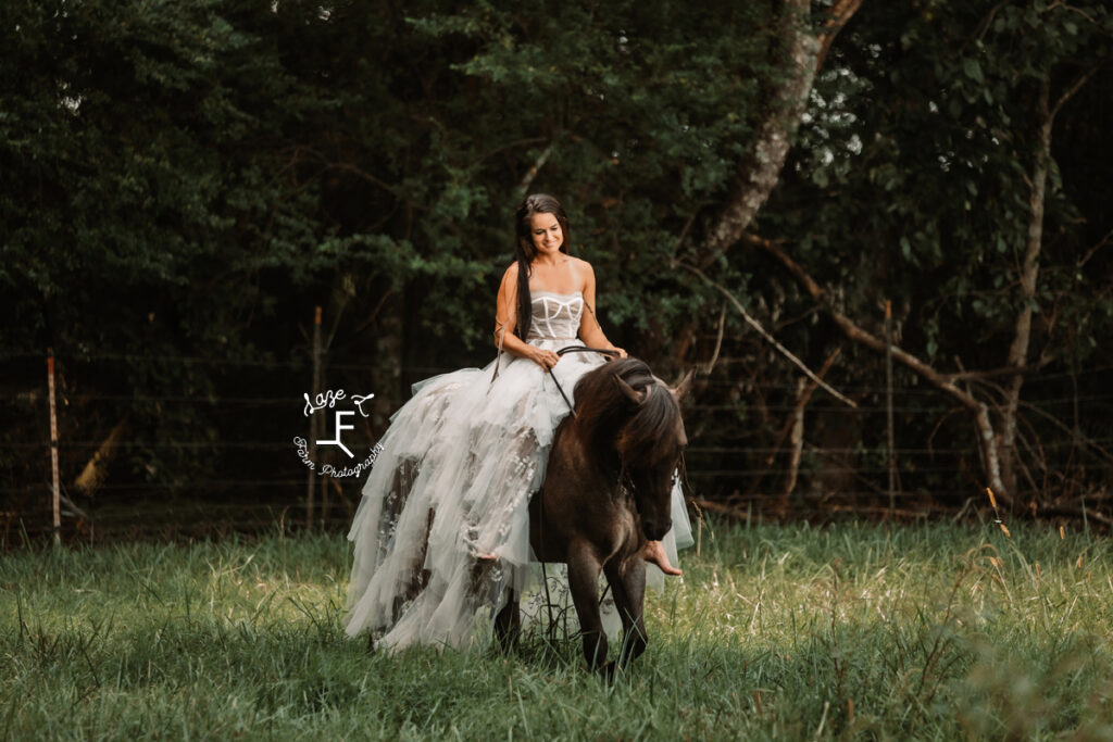 model riding blue roan in white and tan dress