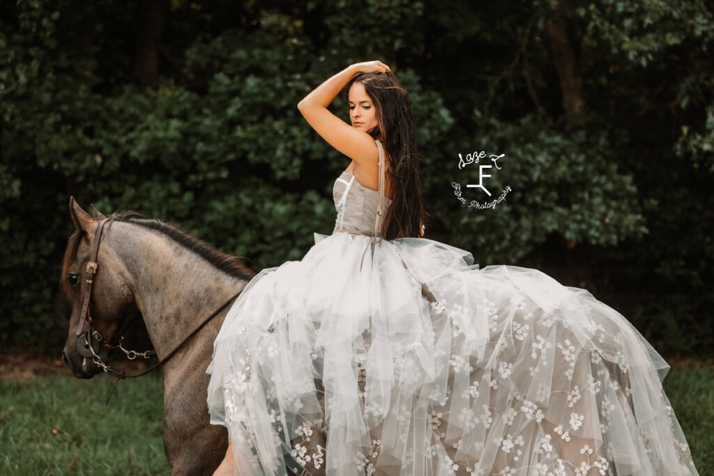 model sitting on horse looking over left shoulder