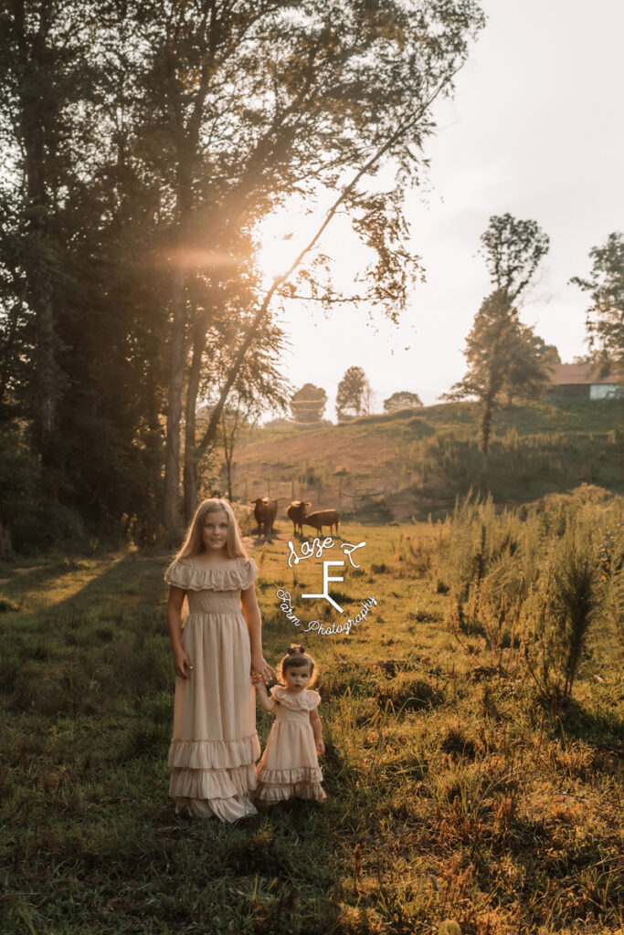 2 little girls holding hands in a field