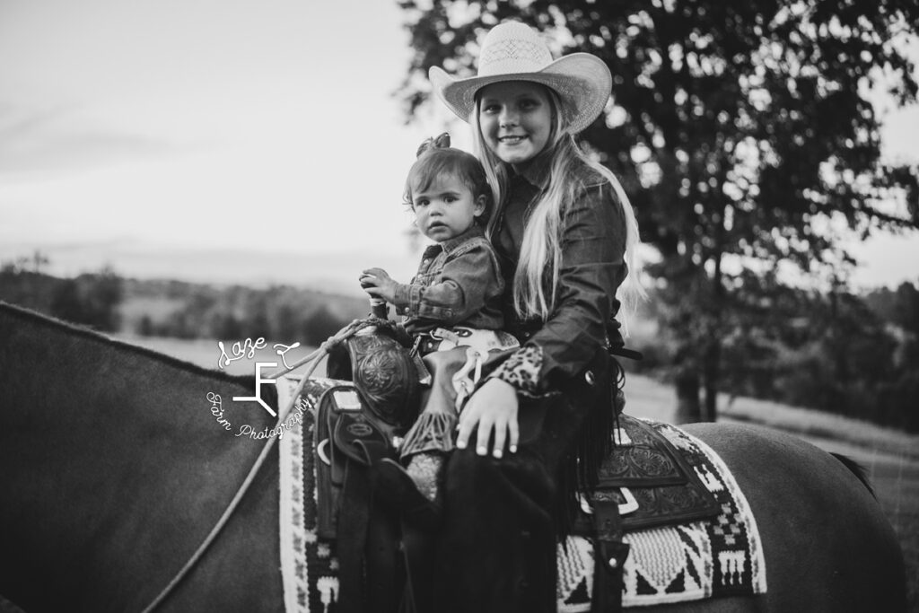 both cowgirls on horse back in black and white
