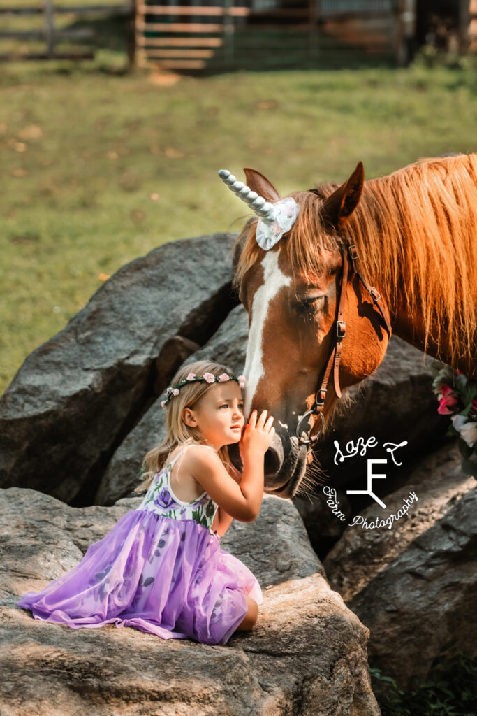 little girl dressed as princess with unicorn horse