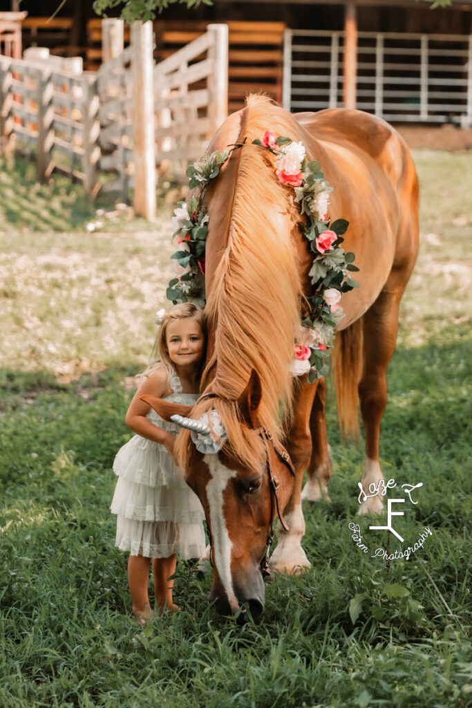 little girl standing with unicorn horse