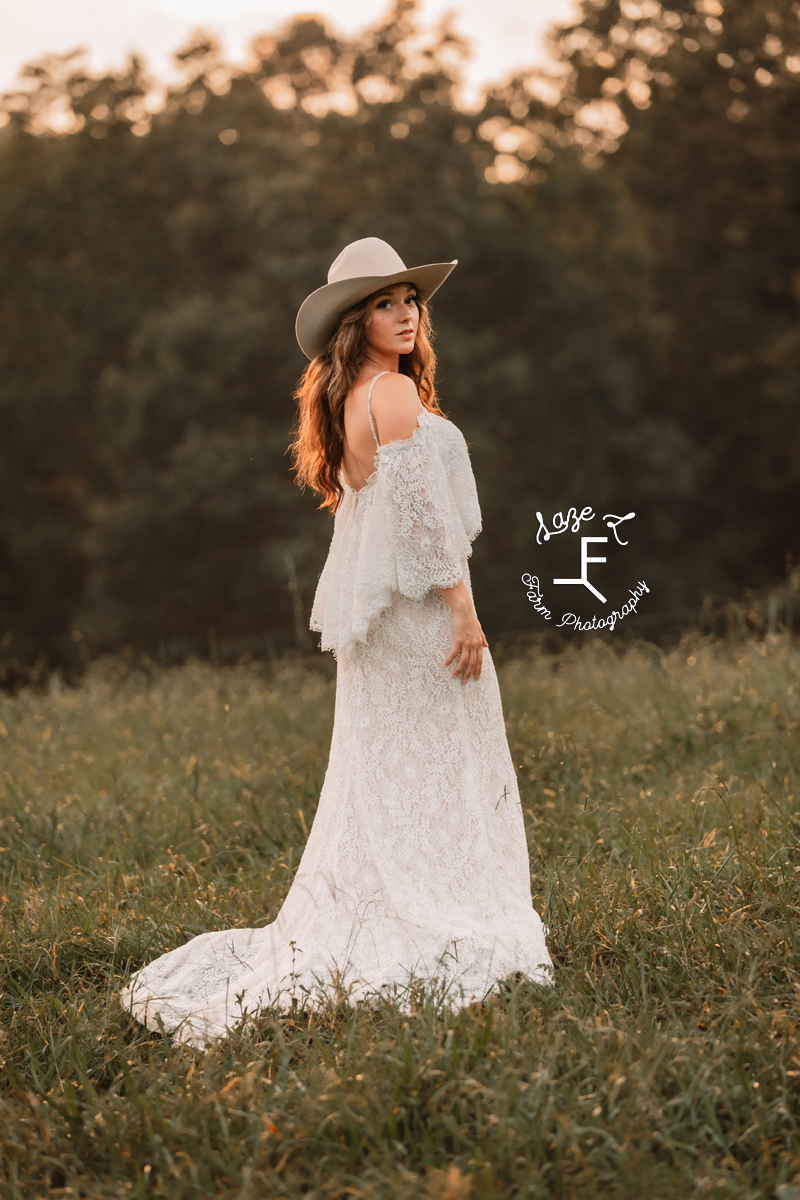 western bride wearing cowgirl hat looking over shoulder